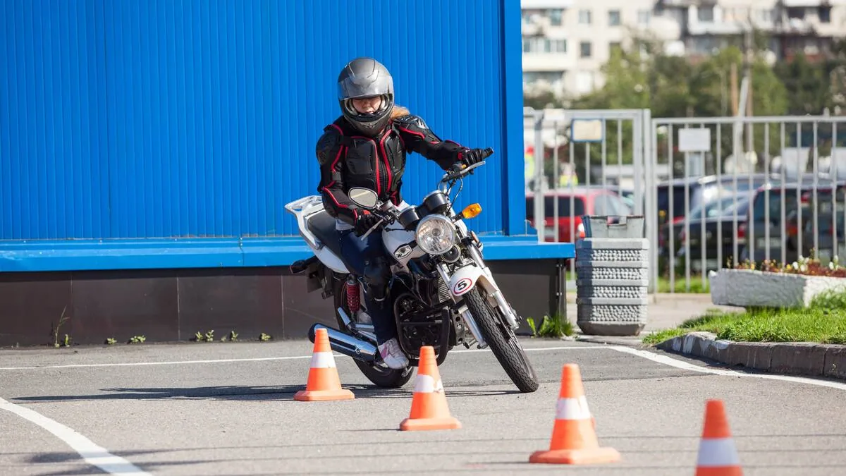 Motociclista practicando maniobras de conducción entre conos
